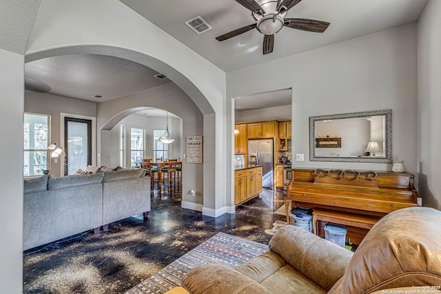 living room featuring ceiling fan and a textured ceiling