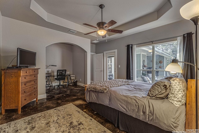 bedroom with ceiling fan and a raised ceiling