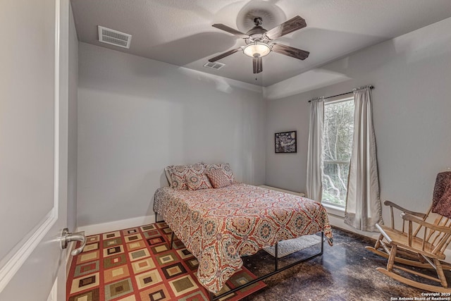 bedroom with ceiling fan and a textured ceiling