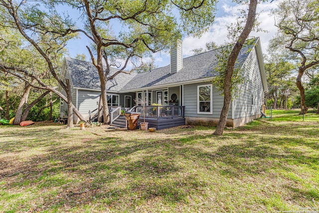 rear view of house with a deck and a lawn