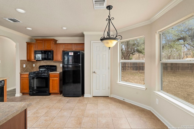 kitchen with tasteful backsplash, light tile patterned floors, ornamental molding, pendant lighting, and black appliances