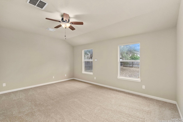 carpeted spare room featuring vaulted ceiling and ceiling fan