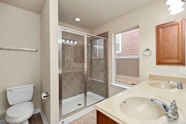 bathroom featuring vanity, tile patterned flooring, toilet, and walk in shower