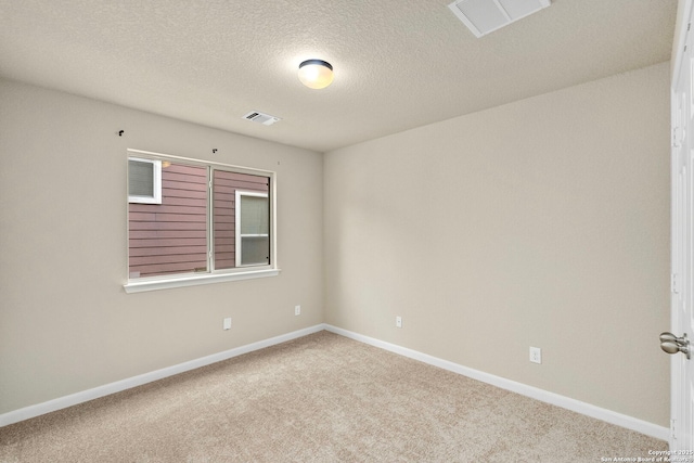 carpeted spare room with a textured ceiling