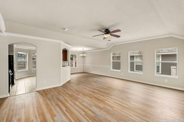 unfurnished living room featuring ceiling fan with notable chandelier, light hardwood / wood-style floors, vaulted ceiling, and a textured ceiling