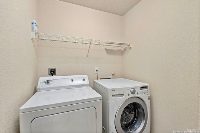 clothes washing area with washer and clothes dryer