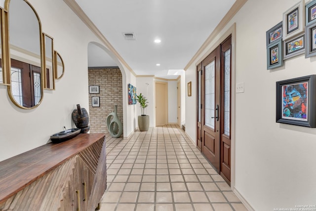 corridor featuring light tile patterned floors and crown molding