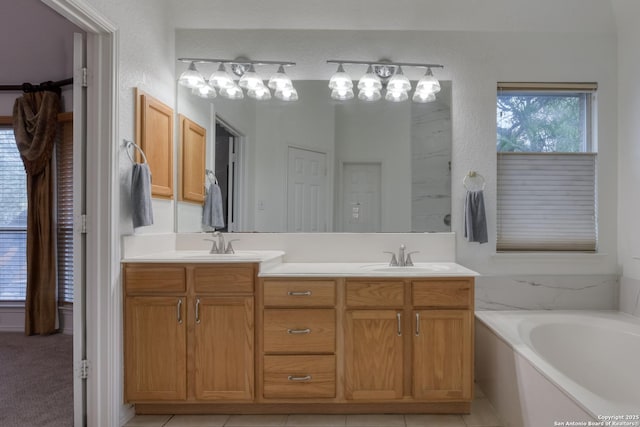 bathroom featuring vanity, a bath, and tile patterned floors