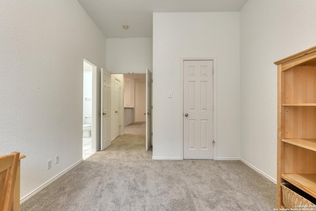 unfurnished bedroom with light colored carpet and ensuite bathroom