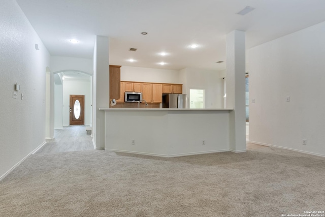 unfurnished living room featuring light carpet