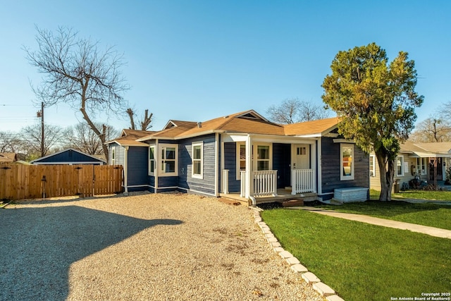 single story home with a front lawn and covered porch