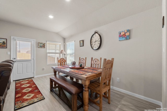 dining area with lofted ceiling and light hardwood / wood-style flooring