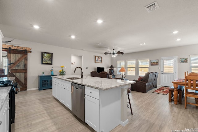 kitchen featuring sink, dishwasher, white cabinetry, black range with electric stovetop, and a barn door