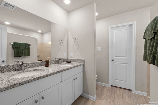 bathroom with vanity, toilet, hardwood / wood-style floors, and walk in shower