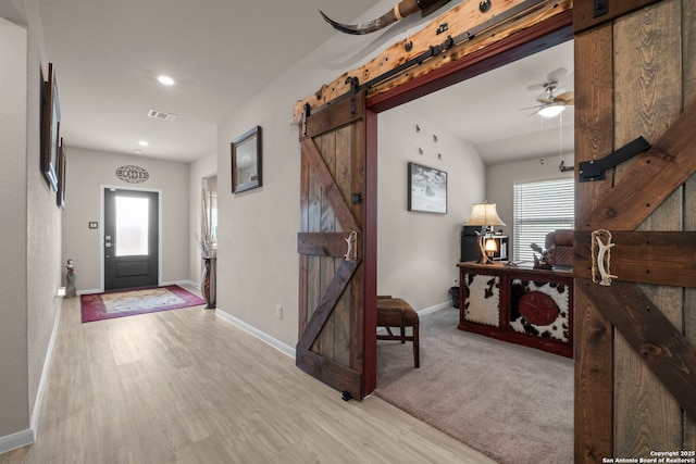 entryway featuring a wealth of natural light, light hardwood / wood-style floors, and a barn door