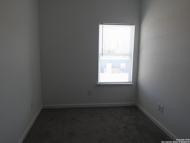 unfurnished room featuring dark colored carpet