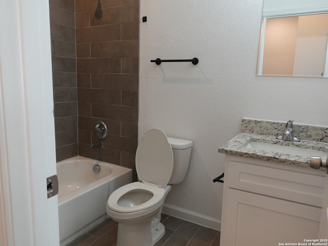 full bathroom featuring tiled shower / bath, vanity, and toilet