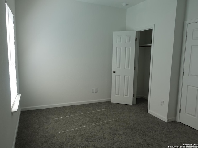 unfurnished bedroom with dark colored carpet