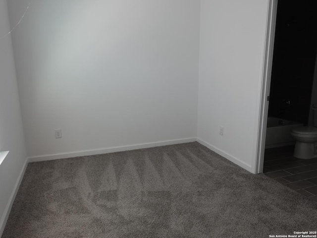 unfurnished bedroom featuring dark carpet