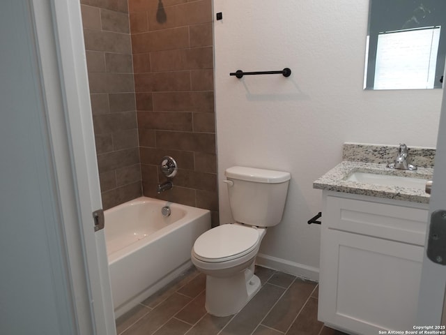 full bathroom featuring vanity, tiled shower / bath, and toilet