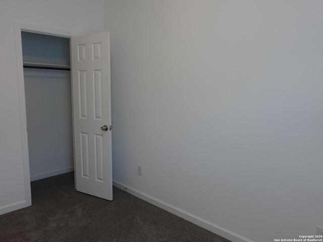 unfurnished bedroom featuring dark colored carpet