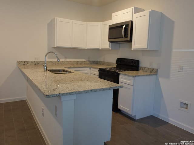 kitchen with sink, dark hardwood / wood-style floors, light stone counters, white cabinets, and kitchen peninsula