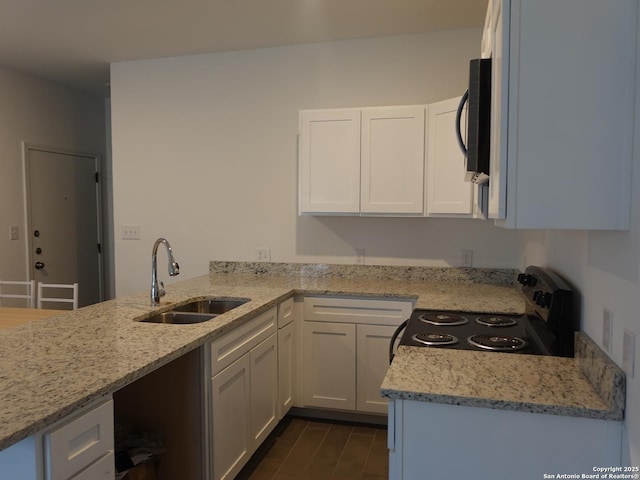 kitchen with sink, white cabinetry, black appliances, light stone countertops, and dark hardwood / wood-style flooring