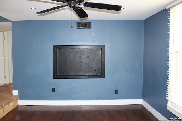 spare room featuring dark wood-type flooring and ceiling fan