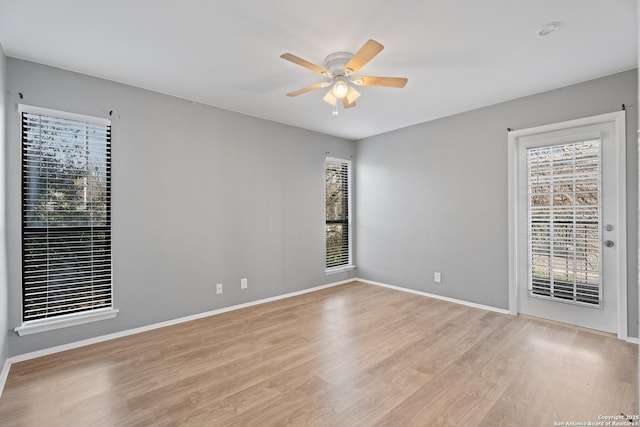 spare room with ceiling fan and light wood-type flooring