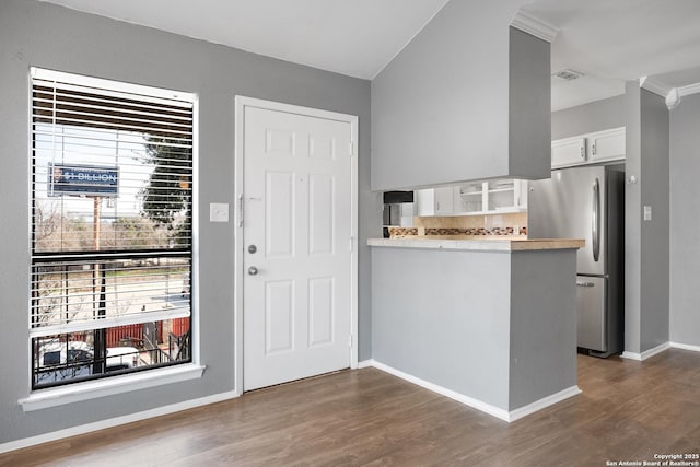 kitchen with stainless steel refrigerator, backsplash, dark hardwood / wood-style flooring, white cabinets, and kitchen peninsula