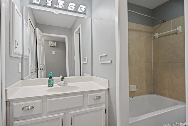 bathroom featuring tiled shower / bath combo and vanity