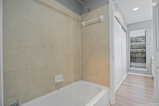 bathroom featuring wood-type flooring and tiled shower / bath combo