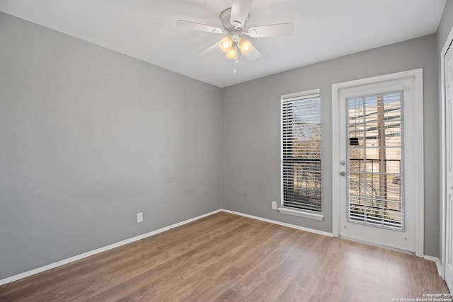 unfurnished room featuring ceiling fan, hardwood / wood-style floors, and a wealth of natural light