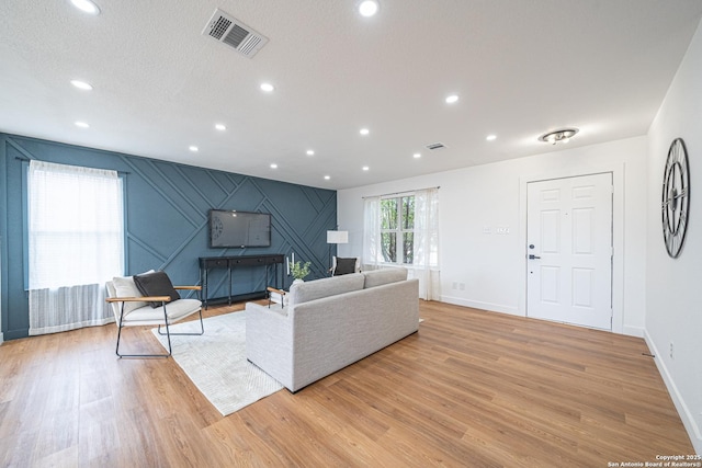 living room featuring a textured ceiling and light wood-type flooring