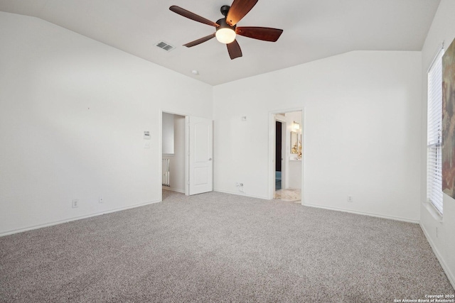 unfurnished bedroom featuring ceiling fan, light colored carpet, ensuite bathroom, and vaulted ceiling