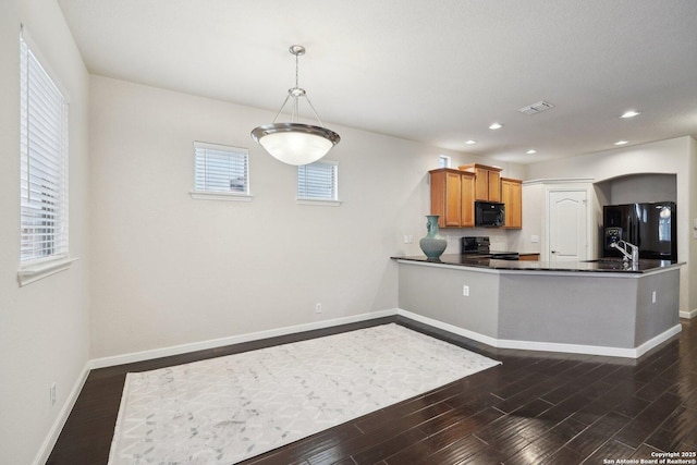 kitchen with decorative light fixtures, dark hardwood / wood-style floors, black appliances, and kitchen peninsula