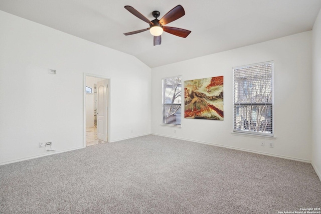 empty room featuring vaulted ceiling, light colored carpet, and ceiling fan