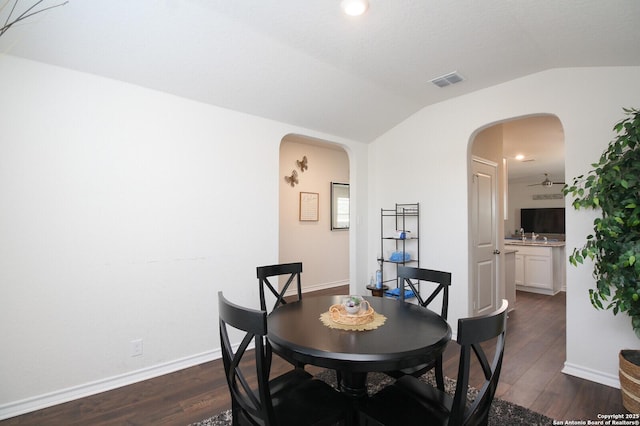 dining space featuring lofted ceiling and dark wood-type flooring