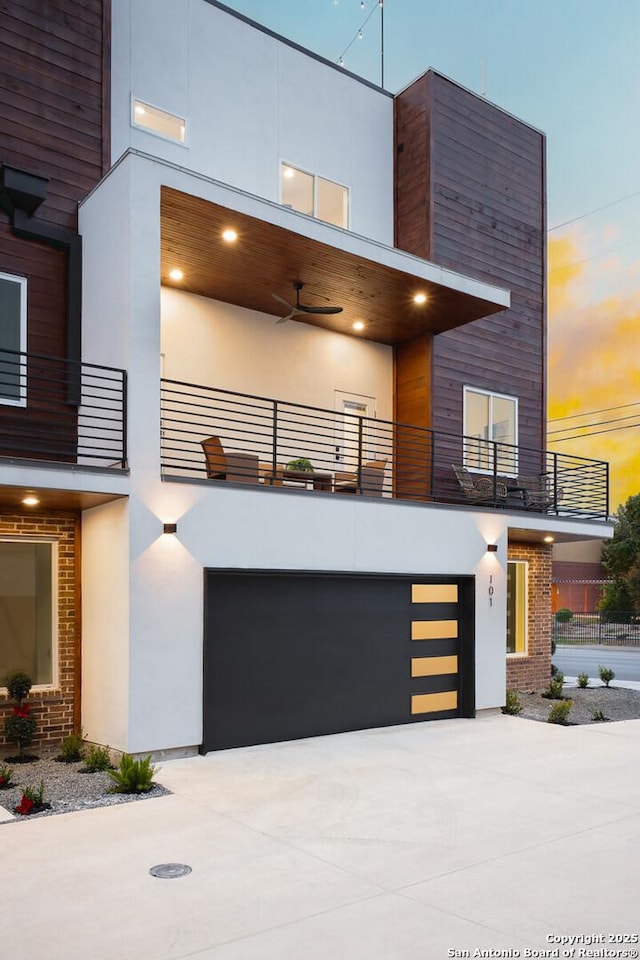 contemporary home featuring ceiling fan, a garage, and a balcony