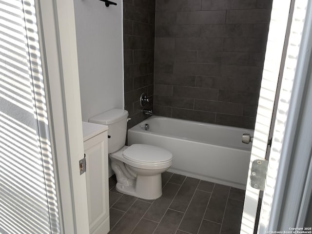 full bathroom with tiled shower / bath, vanity, and toilet