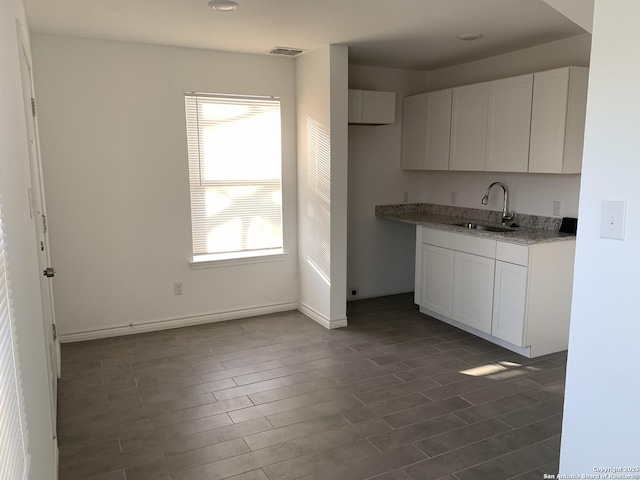 kitchen featuring sink, dark wood-type flooring, and white cabinets