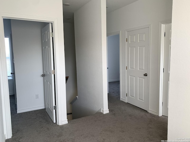 hallway featuring dark colored carpet