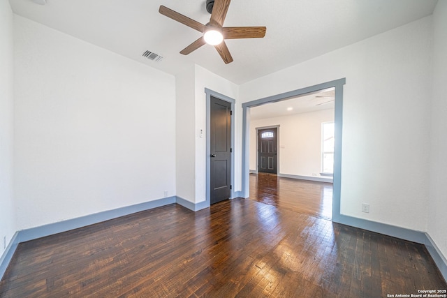 empty room with ceiling fan and dark hardwood / wood-style floors