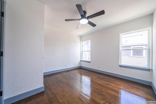 spare room featuring dark hardwood / wood-style floors, a textured ceiling, and ceiling fan