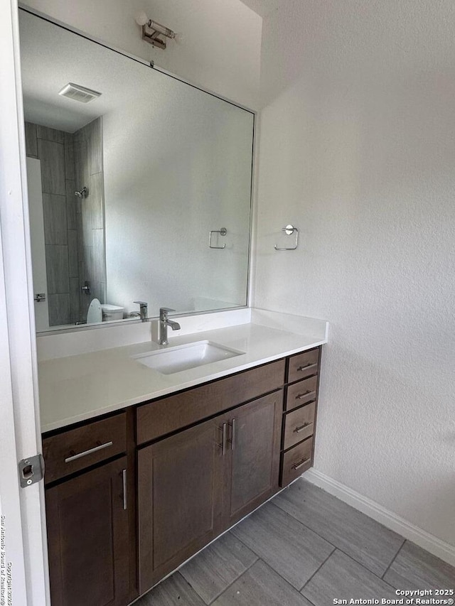 full bathroom with vanity, baseboards, and a shower