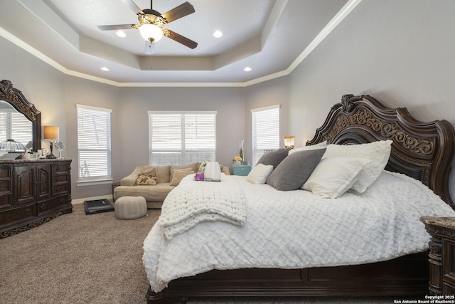 bedroom with crown molding, ceiling fan, a tray ceiling, and carpet