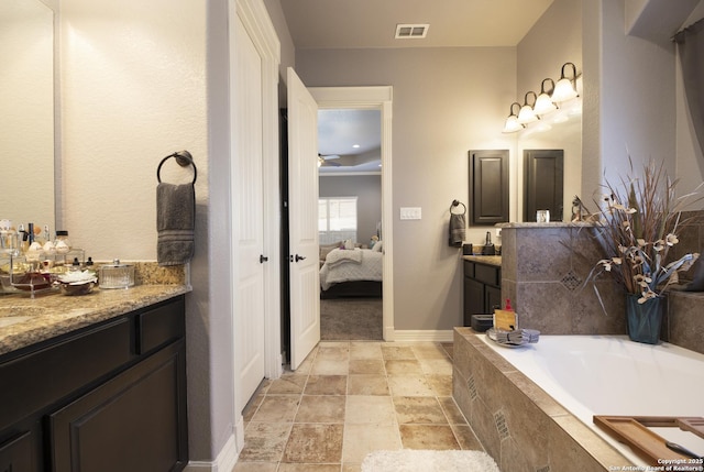 bathroom with vanity and a relaxing tiled tub