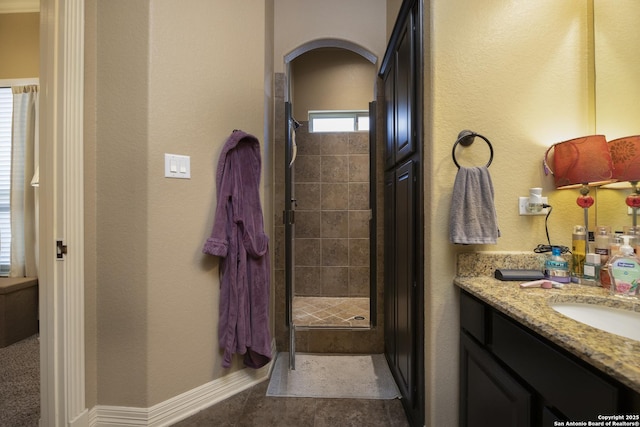 bathroom featuring vanity, a shower with shower door, and tile patterned floors