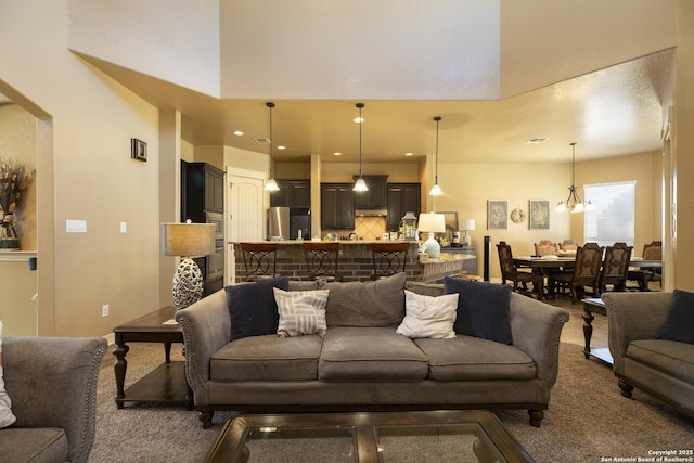 living room with an inviting chandelier and a towering ceiling