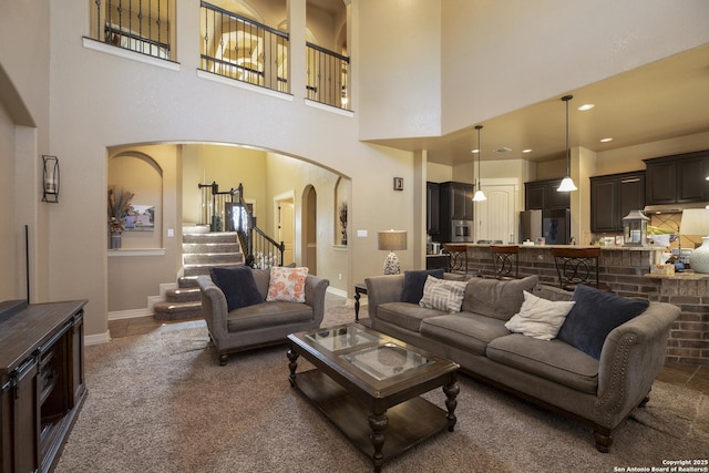 living room with dark colored carpet and a high ceiling